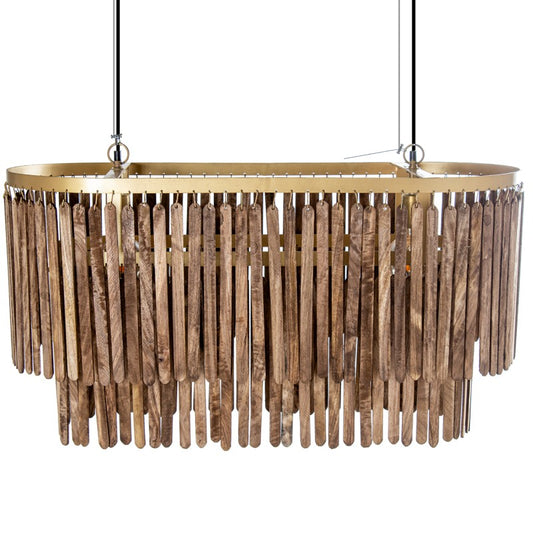 Esta lámpara de techo rectangular (90x40x40cm) de estilo bohemio crea un ambiente cálido y acogedor con sus flecos de madera natural que caen en cascada desde una estructura rectangular de hierro dorado.  El diseño original y la combinación de materiales la convierten en una pieza única para iluminar y decorar espacios amplios como salones, comedores o halls de entrada. Utiliza una bombilla E27 de máximo 25W (no incluida) y cuenta con un cable de 100cm para ajustarla a la altura deseada.